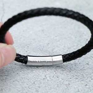 Puede incluir: Pulsera de cuero negro con cierre plateado grabado con las palabras "Daddy I love you".