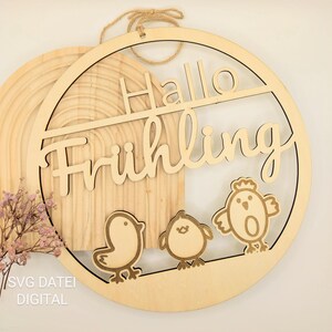 May include: A wooden round sign with the text "Hallo Frühling" in a decorative font. The sign is decorated with three small, stylized chicks.
