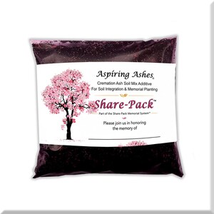Front of a pink Aspiring Ashes Share-Pack bag filled with dark cremation soil additive and a pink flowering-tree dedication label, designed to portion ashes for a personal memorial tree, flower, shrub or container garden.