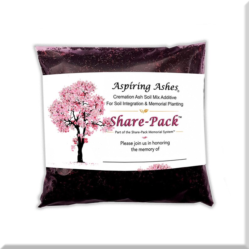 Front of a pink Aspiring Ashes Share-Pack bag filled with dark cremation soil additive and a pink flowering-tree dedication label, designed to portion ashes for a personal memorial tree, flower, shrub or container garden.