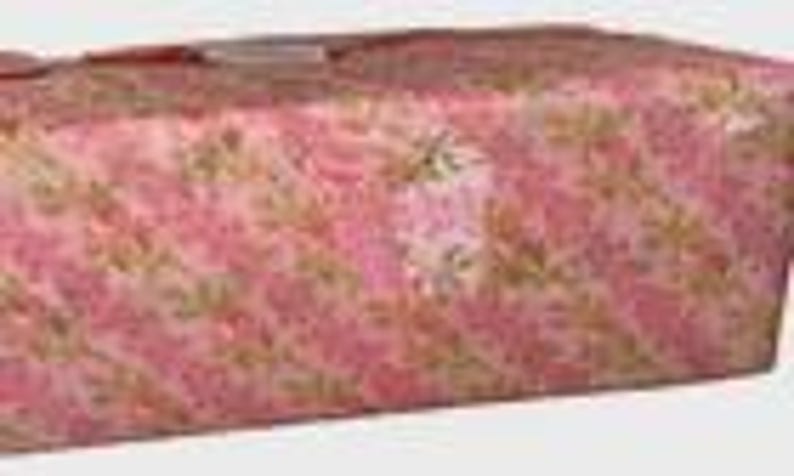 May include: A rectangular gift box wrapped in pink floral patterned paper. The paper has a repeating pattern of pink flowers and green leaves on a pink background. A small white tag is attached to the top of the box.