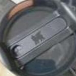 Puede incluir: Una tapa circular de pl&aacute;stico negro para vaso con un mecanismo de cierre deslizante. La tapa tiene una secci&oacute;n rectangular elevada en el centro con un peque&ntilde;o logotipo de oso en relieve. El dise&ntilde;o incluye un borde circular y una zona hundida.