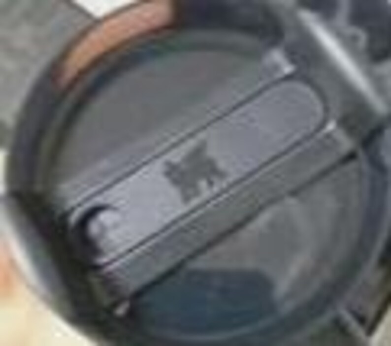 Puede incluir: Una tapa circular de pl&aacute;stico negro para vaso con un mecanismo de cierre deslizante. La tapa tiene una secci&oacute;n rectangular elevada en el centro con un peque&ntilde;o logotipo de oso en relieve. El dise&ntilde;o incluye un borde circular y una zona hundida.