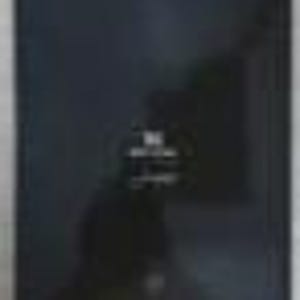 Puede incluir: Una caja rectangular negra con acabado mate. Centrado en la parte frontal hay un logotipo blanco con las letras "DG" sobre el texto "DOLCE & GABBANA" en una fuente sans-serif clara. La caja presenta bordes definidos y un aspecto oscuro.
