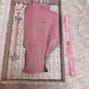 May include: A pink and gold wand and a pink knife are displayed in a wooden box. The wand has a star-shaped top and a clear handle. The knife is pink with a white handle. The box is lined with a floral patterned fabric.