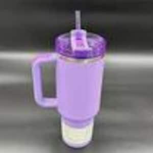 Pu&ograve; includere: Un bicchiere termico viola con manico e cannuccia. Il bicchiere ha una custodia strutturata antiscivolo e un coperchio glitterato. Progettato per mantenere le bevande fredde per ore.