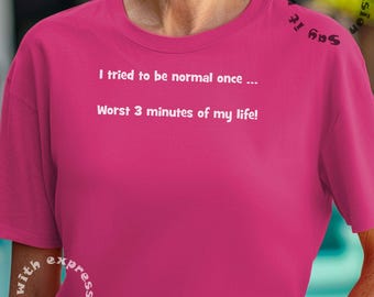 Op de afbeelding: Roze T-shirt met witte tekst die luidt: "Ik heb geprobeerd om een ​​keer normaal te zijn... De slechtste 3 minuten van mijn leven!"