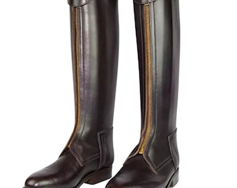 May include: A pair of brown leather riding boots with gold zippers up the front. The boots have a pointed toe and a low heel.