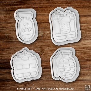 Puede incluir: Un juego de cuatro cortadores de galletas de plástico blanco con formas de bomba nuclear, dinamita con temporizador, un manojo de palos y una granada de mano. El texto 6 PIECE SET - INSTANT DIGITAL DOWNLOAD y 3D CUTTERS es visible.