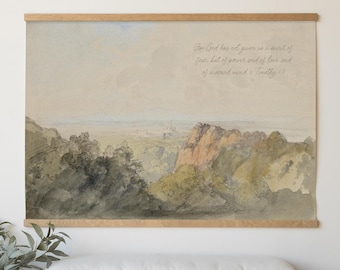 May include: A landscape wall hanging featuring a watercolor painting of hills and trees with the text For God has not given us a spirit of fear, but of power and of love and of a sound mind. 2 Timothy 1:7, framed in light wood.