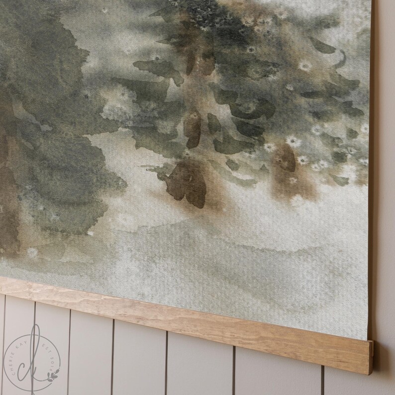 May include: Watercolor print of a forest scene in muted greens and browns. The artwork is mounted on a wooden frame. The painting depicts a serene landscape with soft, blended colors, evoking a sense of tranquility.