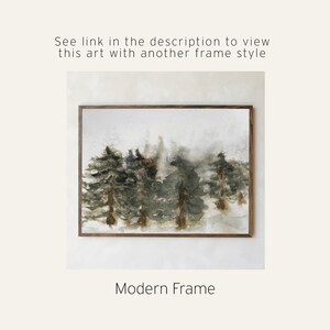 May include: Watercolor painting of a forest scene in muted greens and browns, framed in a dark wood. The artwork features a misty, atmospheric depiction of trees. Text at the bottom reads "Modern Frame". Above the artwork, text reads "See link in the description to view this art with another frame style".