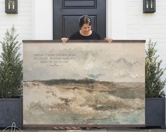 May include: A large rectangular wall hanging featuring a watercolor landscape of rolling hills in muted earth tones. The text reads: Therefore, if anyone is in Christ, he is a new creation. The old has passed away. Behold, the new has come. 2 Corinthians 5:17.