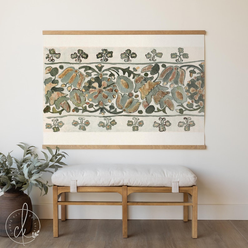 Vintage floral tapestry wall hanging featuring botanical textile print in green and rust tones, styled above a bench in a neutral entryway with wood floors and greenery.