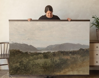 May include: A large rectangular landscape painting featuring a wide valley with dense green trees in the foreground, a calm body of water in the middle ground, and rolling mountains under a pale, overcast sky, framed in dark wood.