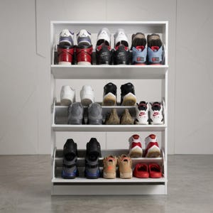 May include: A white, three-tiered shoe rack filled with various sneakers. The shoes are in different colors, including red, black, blue, and white. The rack is made of wood and has a simple, modern design, perfect for organizing footwear.