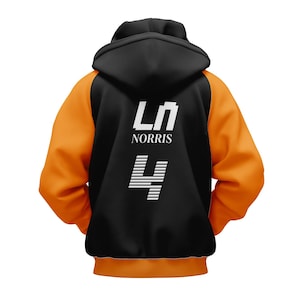 以下が含まれることがあります： 黒とオレンジ色のフード付きスウェットシャツ。背面には白で「LN NORRIS」の文字と数字の「4」がプリントされています。袖と下部はオレンジ色で、フードは黒色です。