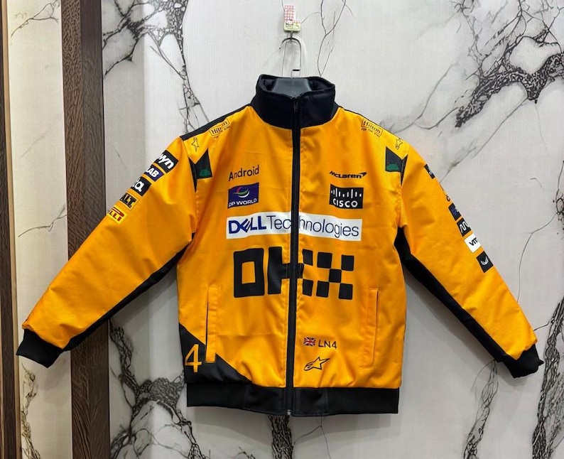 May include: A bright yellow racing jacket with black accents, a black collar, and a full-length zipper. The jacket features multiple sponsor logos, the text "DELL Technologies", and the number "4".