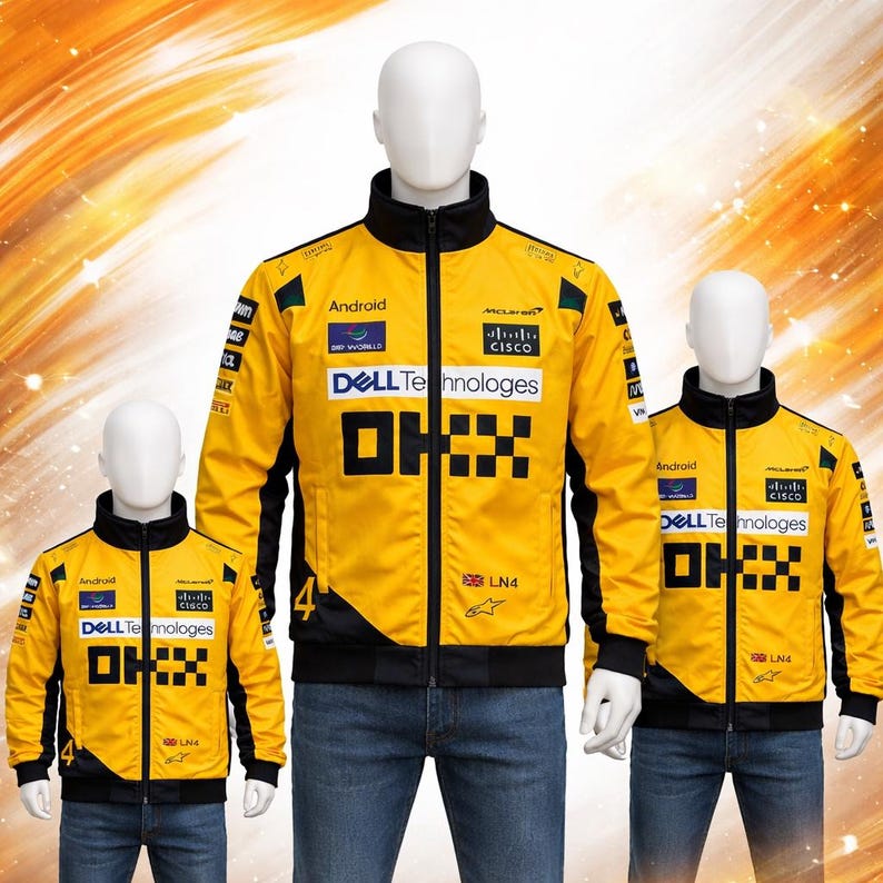 May include: Three yellow and black racing jackets on mannequins. The jackets have multiple sponsor logos, including "Android", "Dell Technologies", and "Cisco". The jackets have a black collar and cuffs, and the number "4" is visible on the sleeve.