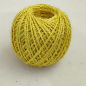 Op de afbeelding: Een bol geel touw, strak gewikkeld met een holle kern. Het touw heeft een getextureerd uiterlijk en een consistente, heldergele kleur. Deze knutselbenodigdheid is geschikt voor diverse doe-het-zelf projecten.