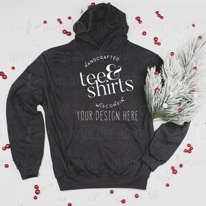 Op de afbeelding: Een donkergrijze hoodie met de tekst "HANDCRAFTED tee & shirts WISCONSIN YOUR DESIGN HERE" gedrukt op de voorkant. De hoodie ligt plat op een wit oppervlak met rode en witte decoratieve accenten.