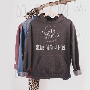 Op de afbeelding: Een donkergrijze hoodie met een witte zak en de tekst "handcrafted tee & shirts Wisconsin" en "your design here".