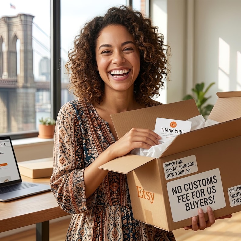 A smiling woman holding a cardboard box with a note inside, standing in front of a window with a bridge in the background.