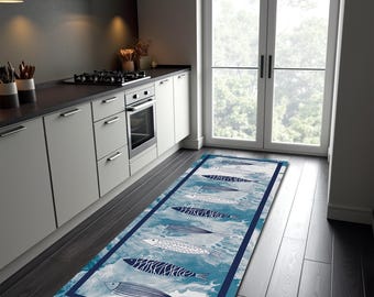 May include: A long rectangular kitchen runner rug featuring a blue and white marbled background with a repeating pattern of stylized fish in various shades of blue and white, enclosed by a solid dark blue border frame along the edges.