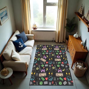 Peut inclure: Un tapis rectangulaire avec un fond noir et un motif coloré d'icônes de jeu. Le motif comprend des manettes de jeu, des claviers, des écouteurs, des éclairs, des cœurs et des épées. Le tapis est posé sur un sol carrelé.