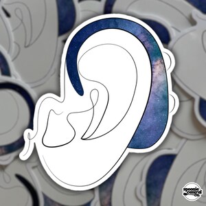 May include: A white sticker featuring a stylized ear design with a dark blue outline and a galaxy-themed fill. The sticker has a minimalist, line-art style. The Spoonie Central Co. logo is in the bottom right corner.