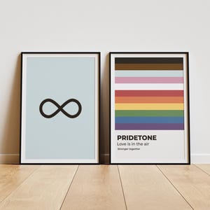 May include: Two framed prints, one with a light blue background and a black infinity symbol, the other with a rainbow pride flag and the text "PRIDETONE Love is in the air Stronger together"