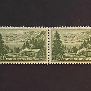 Op de afbeelding: Twee groene Nevada First Settlement Centennial postzegels. Elke postzegel toont een hut, bomen en bergen. De tekst "Nevada First Settlement Centennial 1851-1951" en "3 United States Postage" zijn afgedrukt.