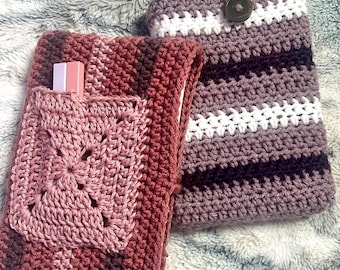 May include: Two crocheted book covers in shades of pink and purple. One cover has a square pocket and the other has a button closure.