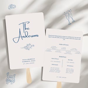 May include: Two off-white wedding program fans with rounded corners and wooden handles. The front features dark blue text reading The Andersons, Villa Arabella, Florence, Italy, 17.08.2026, and a floral sketch. The back lists the order of events and bridal party.
