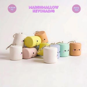 May include: A collection of colorful marshmallow-shaped keychains with smiling faces. The keychains are in various pastel colors, including pink, yellow, blue, and peach. The text "MARSHMALLOW KEYCHAINS" is displayed above the keychains.