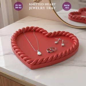 May include: A red heart-shaped jewelry tray with a braided edge, holding a necklace, earrings, and rings. The tray has the text "KNITTED HEART JEWELRY TRAY" and is labeled "STL FILE 3MF FILE" and "DIGITAL FILES".