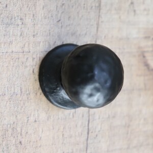 Puede incluir: Pomo de puerta de metal negro con acabado redondo y martillado.