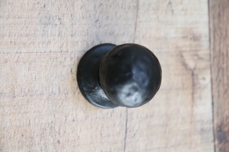 Puede incluir: Pomo de puerta de metal negro con acabado redondo y martillado.