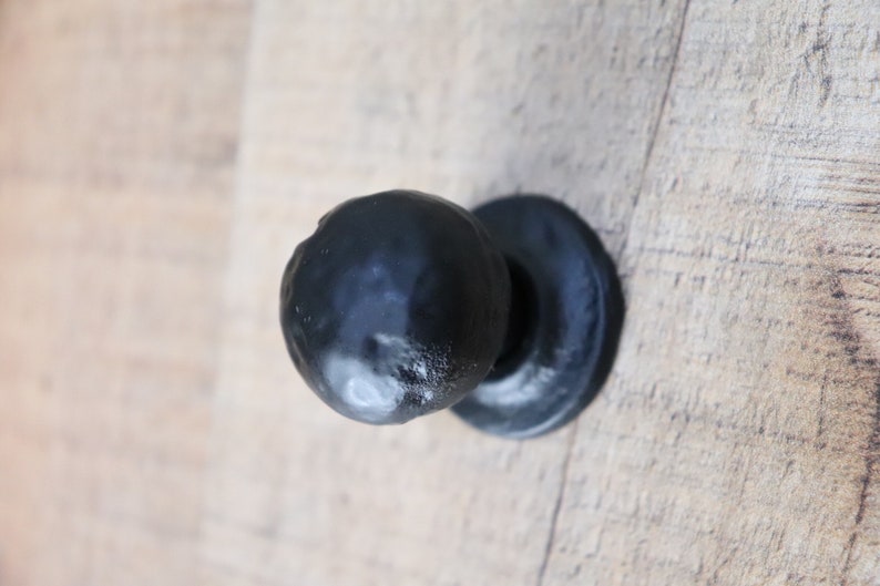 Puede incluir: Pomo de puerta redondo negro con base plana.