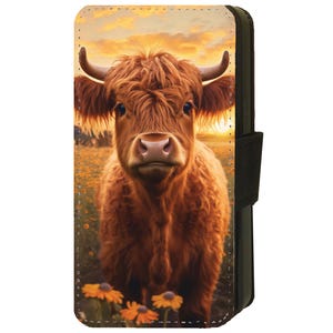 May include: A close-up of a brown Highland cow with long, shaggy fur standing in a field of yellow wildflowers. The cow is looking directly at the camera with a curious expression. The background is a blurry sunset.