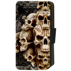 Puede incluir: Una funda para teléfono con un diseño de varios cráneos con detalles intrincados y patrones. Los cráneos están apilados uno encima del otro y tienen un fondo oscuro.