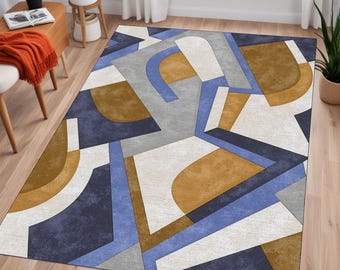 May include: Abstract geometric rug with a white background, blue, grey, and brown shapes. The rug has a modern design.