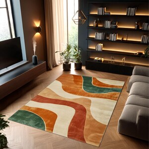 May include: A rectangular area rug with an abstract design in shades of orange, red, green, and cream. The rug features a wavy pattern, adding a modern touch to the room's decor. The rug is placed on a wooden floor.