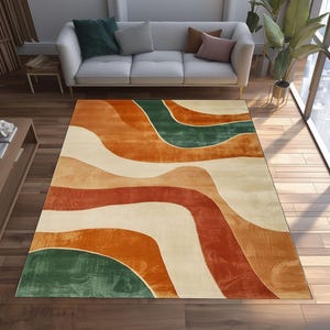 May include: A rectangular area rug with a flowing, abstract design in shades of orange, red, green, and cream. The rug's pattern resembles layered waves, creating a modern and artistic look. The rug is placed on a hardwood floor.