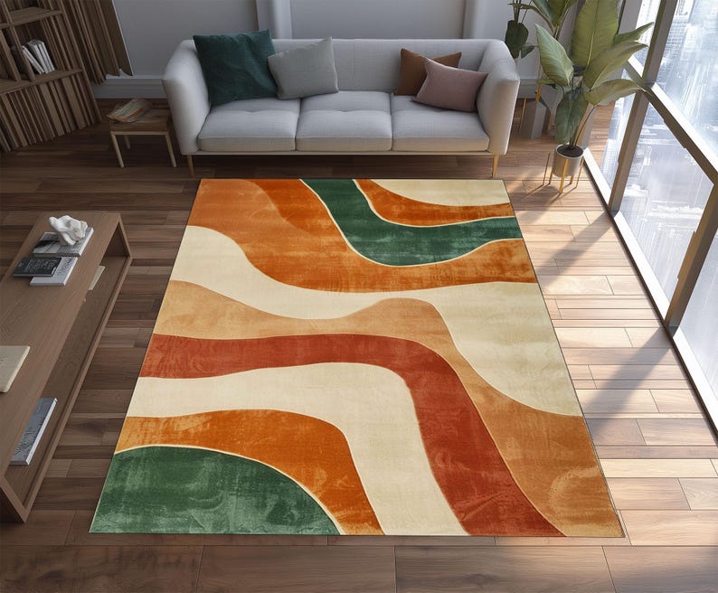 May include: A rectangular area rug with a flowing, abstract design in shades of orange, red, green, and cream. The rug's pattern resembles layered waves, creating a modern and artistic look. The rug is placed on a hardwood floor.