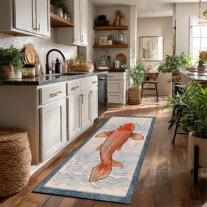 Könnte beinhalten: Rechteckiger Küchenteppich mit einem Design einer orange-weißen Koi-Karpfen. Der Fisch befindet sich mittig auf einem hellblauen Hintergrund mit blauen Wellenmustern und einem dunkelblauen Rand. Der Teppich liegt auf einem Holzboden.