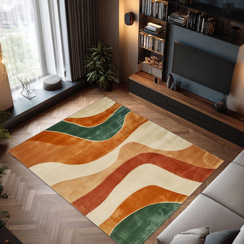 May include: A rectangular area rug with a wavy pattern in shades of orange, green, and cream. The rug is placed on a hardwood floor in a living room setting. The design features flowing, organic shapes.