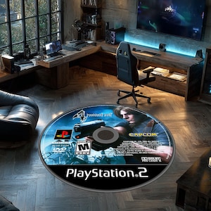 Könnte beinhalten: Runder Teppich mit dem Design der Resident Evil 4 Videospiel-Disc. Der Teppich hat einen blauen Hintergrund mit einer Figur, die eine Waffe hält. Das PlayStation 2-Logo befindet sich unten.