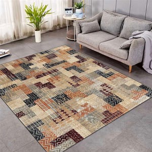 Könnte beinhalten: Ein mehrfarbiger Teppich mit geometrischem Muster in Braun-, Beige-, Rot- und Schwarztönen. Der Teppich hat ein Patchwork-Design mit verschiedenen Formen und Größen von Quadraten und Rechtecken.