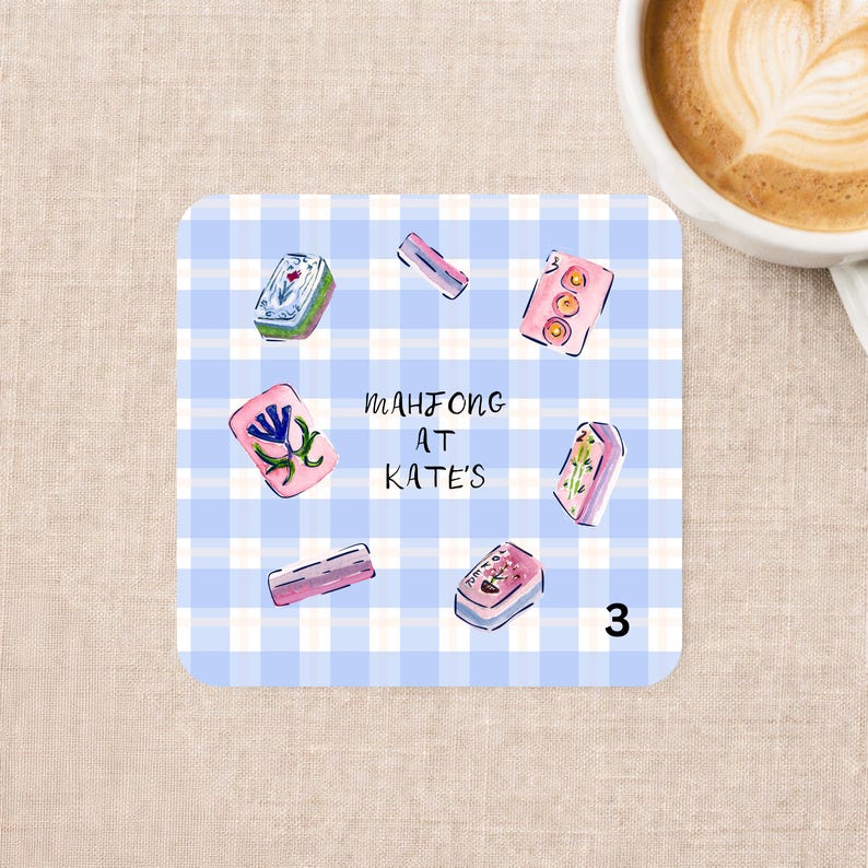 May include: A square coaster with a light blue and white gingham pattern featuring illustrations of various mahjong tiles arranged in a circle. The text "MAHJONG AT KATE'S" is printed in the center in a simple black handwritten font.